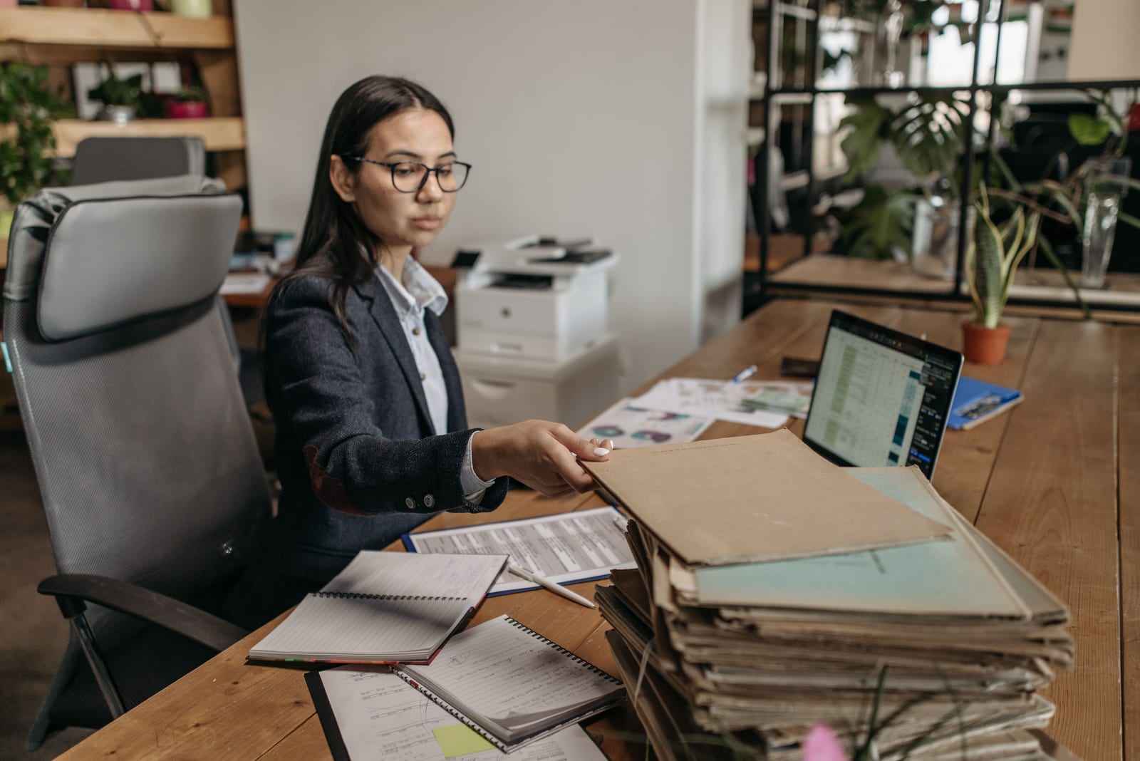A clinician at a desk beside a stack of case files